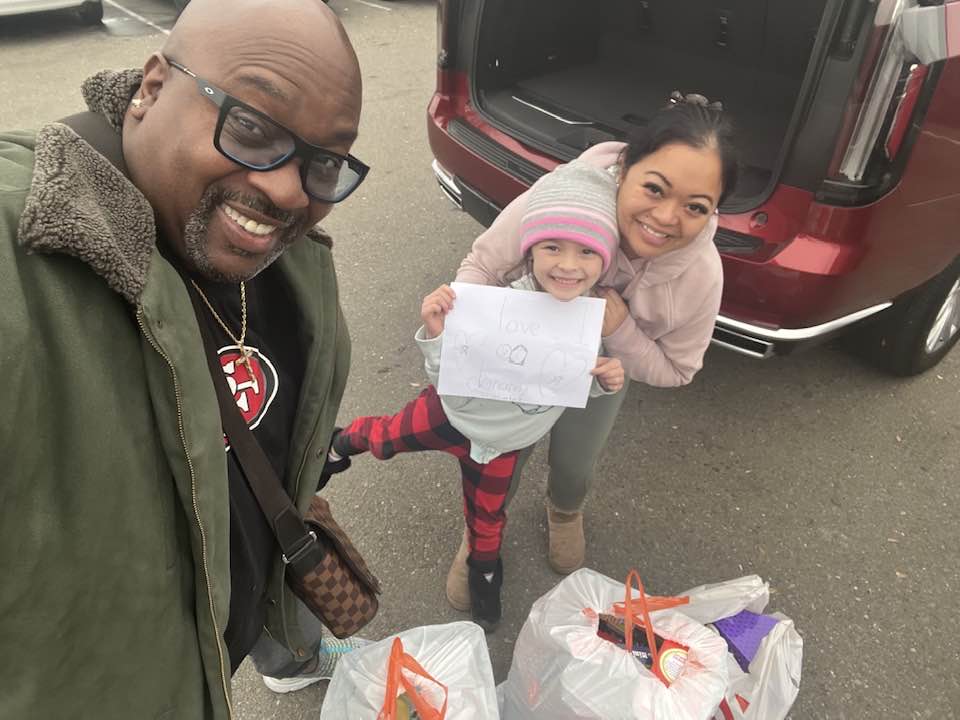 Tony Mims of Mims Corner with a Mom and Child and Groceries